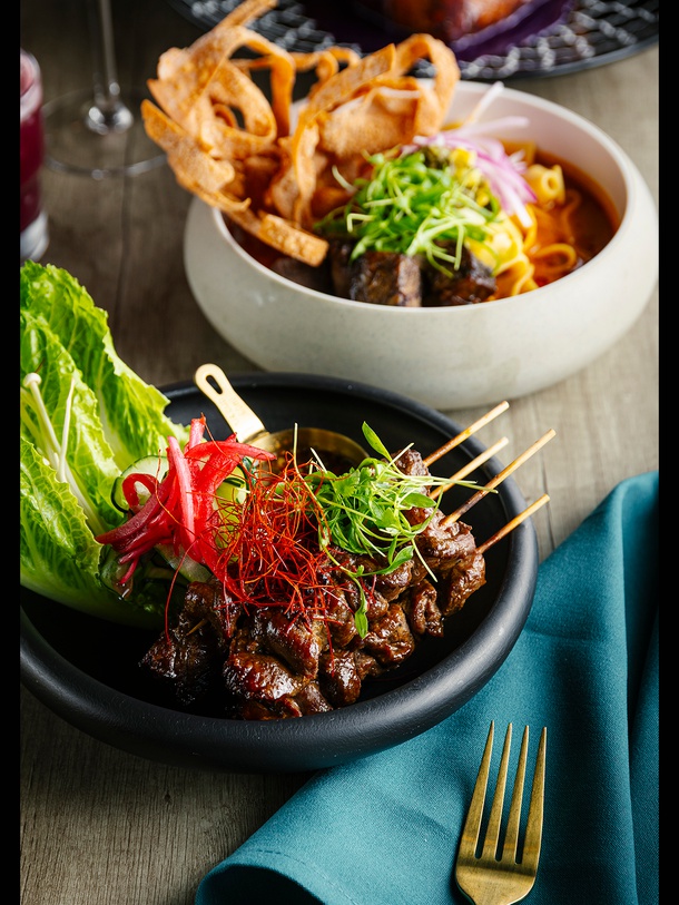 Blue Orchid Thai Kitchen’s Tiger Cry on a Stick (front) and braised short rib Khao Soi.