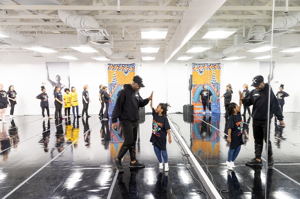 Justin Bryant, artistic dance director, gets a high five from Amari Childs, 7, the son of a dance student, during a class at the Legacy Theatre.