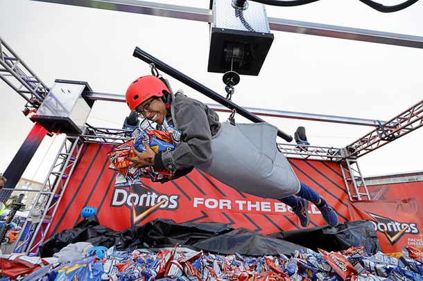 Las Vegas Weekly reporter Amber Sampson tries out the Doritos human claw game in the East Harmon Zone Wednesday, Nov. 19, 2025. Sampson grabbed 32 bags of Doritos.