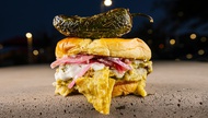 The Chilaquiles Burger is basically brunch on a bun, with tortilla chips tossed in tangy salsa verde and Mexican crema.