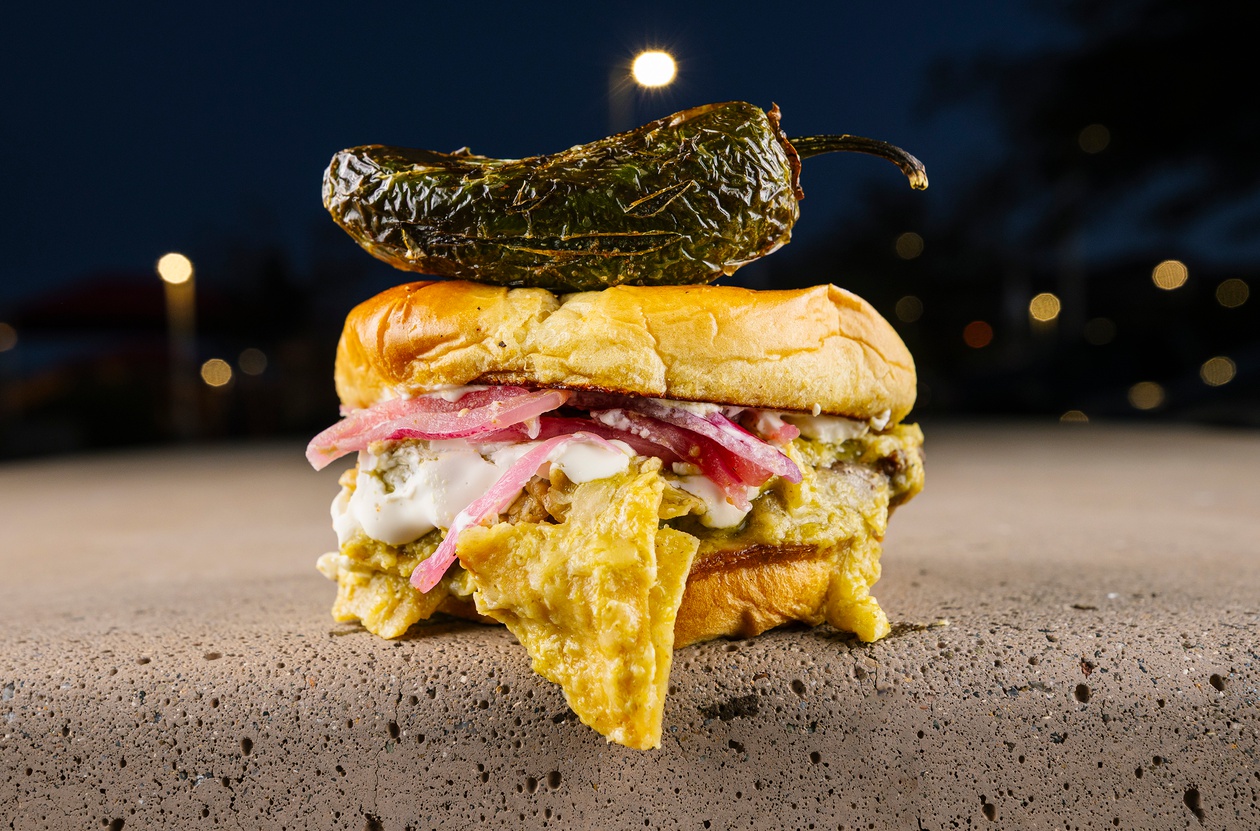 The Chilaquiles Burger is basically brunch on a bun, with tortilla chips tossed in tangy salsa verde and Mexican crema.