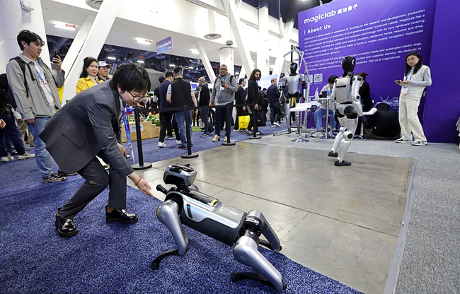 An attendee interacts with robot dog in the Magiclab booth during CES 2026 at the Las Vegas Convention Center Tuesday, Jan 6, 2026.