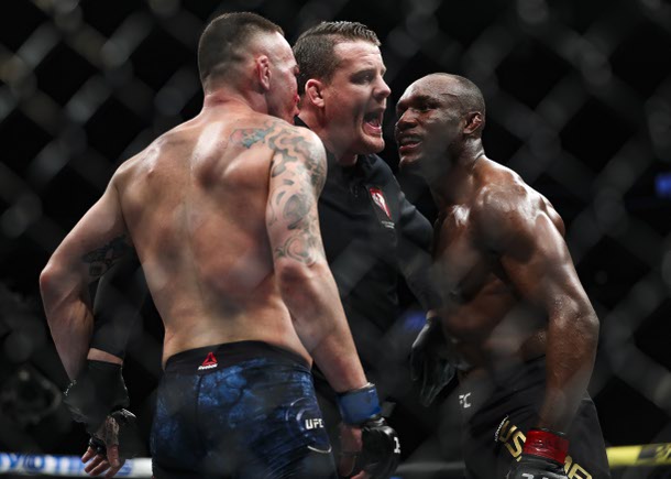 Referee Marc Goddard stands between Colby Covington, left, and Kamaru Usman during their title fight at UFC 245 at T-Mobile Arena on December 14, 2019.