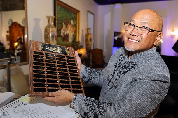 Ron Cabildo, director of global marketing and strategic alliances for the Filipino American Museum, displays sponsors names on a plaque during a soft opening of the Filipino American Museum in the Boulevard mall Saturday, Feb. 7, 2026.