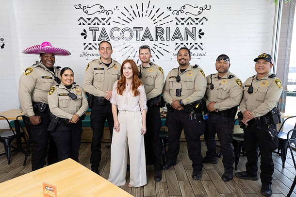 Kristen Corral, co-founder of Tacotarian, poses with Metro Police officers in the restaurant in the Arts District Tuesday, Feb. 24, 2026. From left: K. Flowers, E. Arellano, Capt. Adam Seeley, P. Zarate, L. Ramos. I Unaaite, and R. Ricafuenter. Corral and Seely worked together to change how downtown businesses report and address crime-related issues in their area.