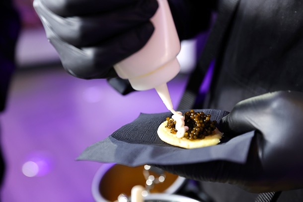 A mobile caviar waiter from Stardust Caviar makes a caviar hors d’oeuvre during the C-Suite Honors event in the Zouk Nightclub at Resorts World Wednesday, Feb. 25, 2026.