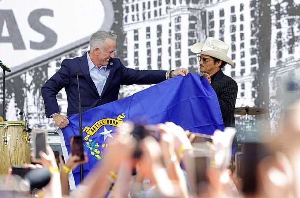 Nevada Gov. Joe Lombardo, left, presents entertainer Bruno Mars with a Nevada state flag after a parade Friday, April 10, 2026, in Las Vegas. The governor proclaimed April 10, 2026 as “Bruno Mars Day” and Clark County renamed a street to Bruno Mars Drive in his honor.