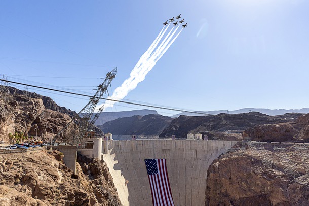 The United States Air Force Thunderbirds, the official aerial demonstration team of the U.S. Air Force, perform a flyover above Hoover Dam, adorned with a 300-foot-wide by 150-foot-tall American flag, Tuesday, June 30, 2026. The Thunderbirds will travel to Washington, D.C., for the Salute to America250 celebration.