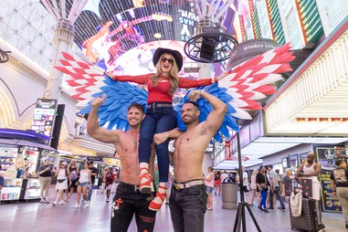Karina, a tourist from Nicaragua, poses for a photo with street performers Justin Wright, left, and Emilio Rodriguez at the Fremont Street Experience on June 26 in Downtown Las&nbsp;Vegas.